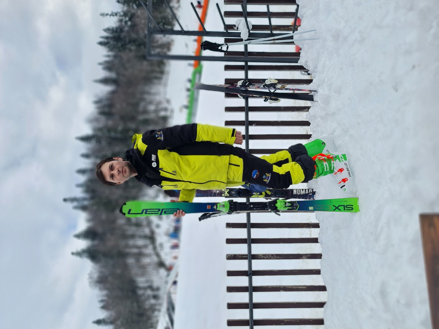 Instruktor Ski kluba Reljina sa skijama pored drvene ograde